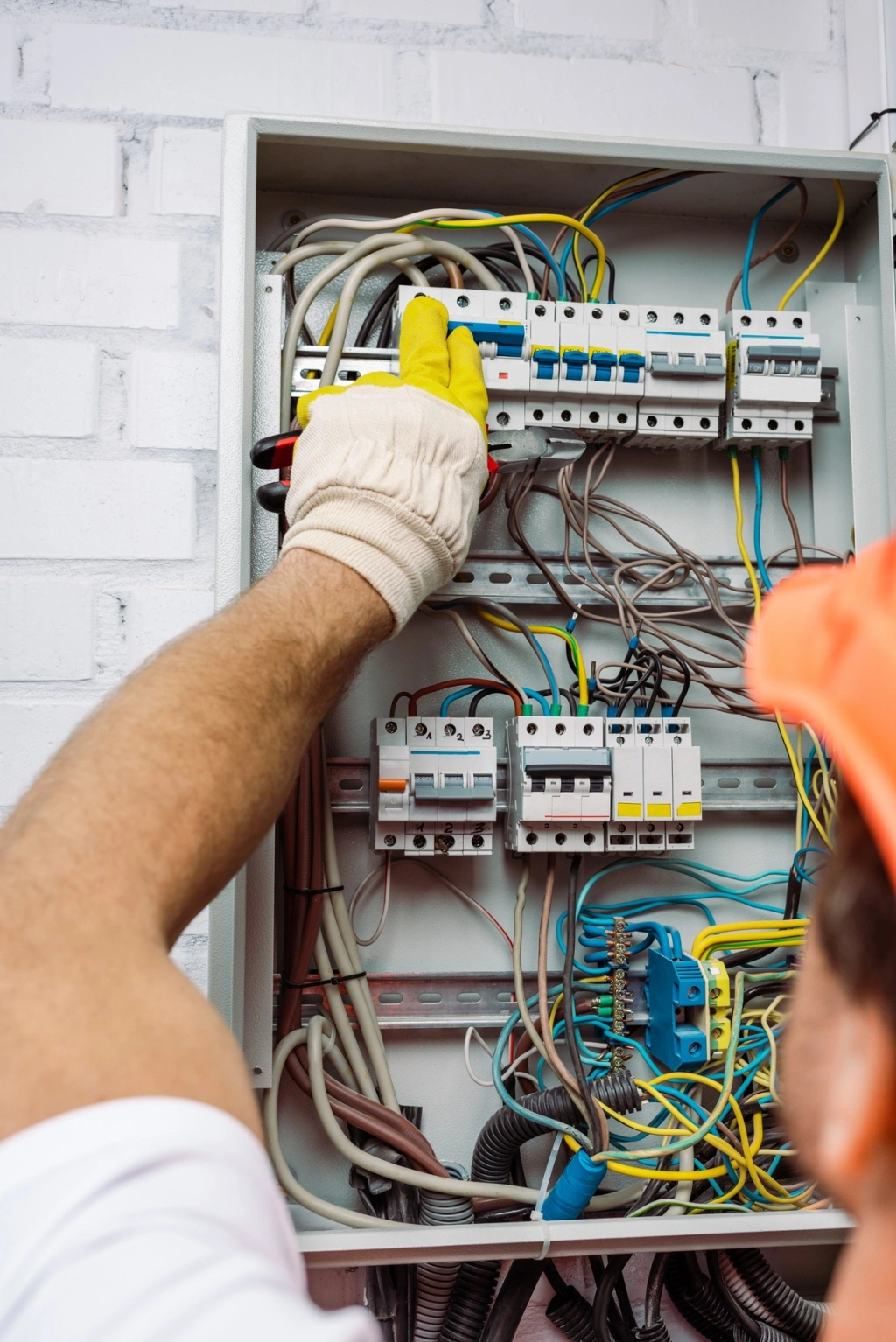 Électricien travaillant sur un tableau électrique avec des câbles et des disjoncteur